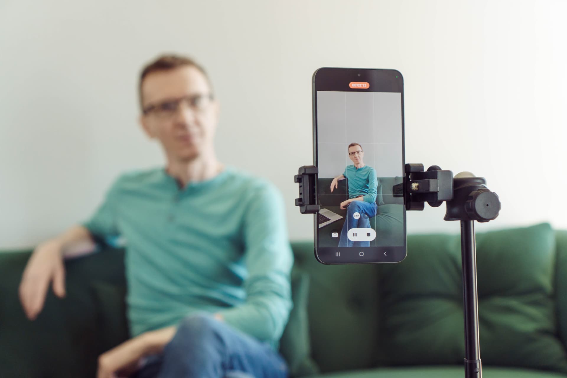 A person recording a short video answer on a phone, mounted simply